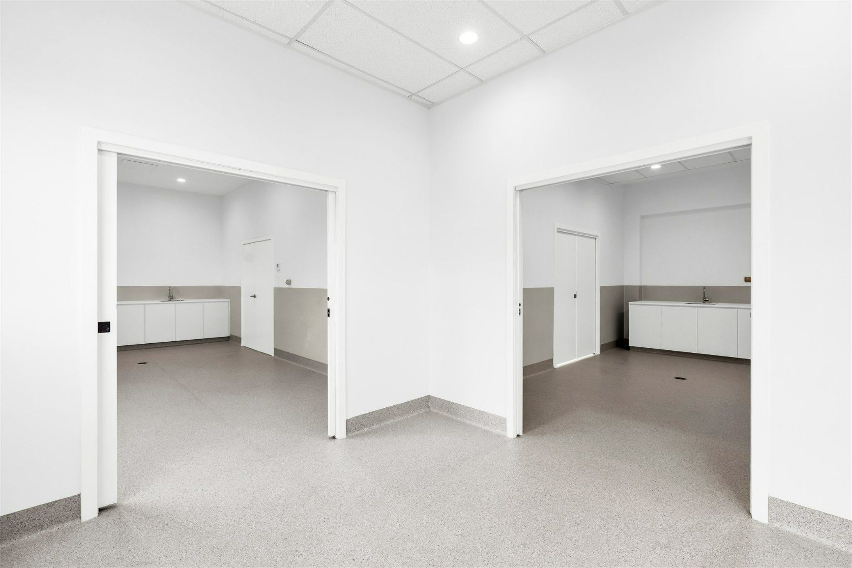 A Large Empty Room With White Walls and a Concrete Floor — Moltus Construction in Braddon,  ACT