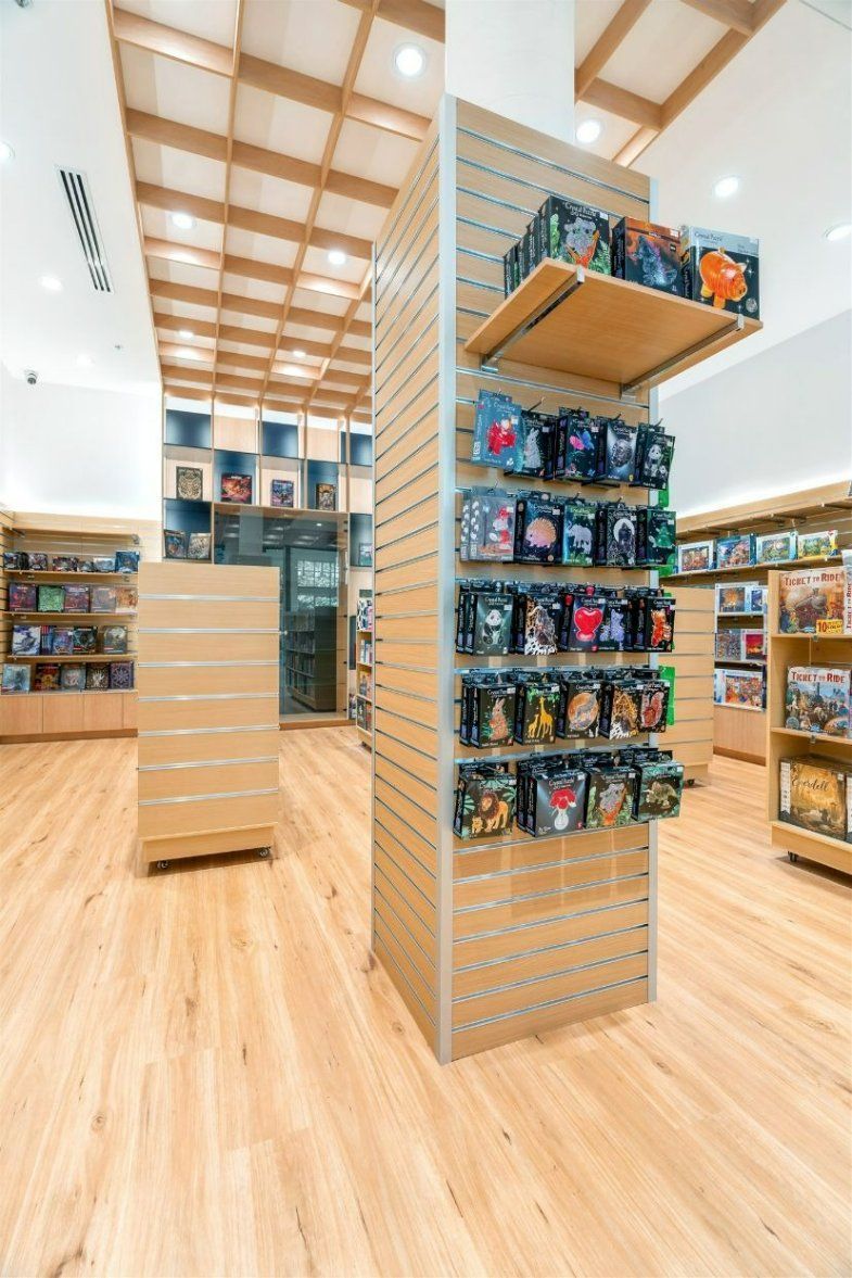 A Book Store With Wooden Floors and Shelves Filled With Books — Moltus Construction in Braddon,  ACT