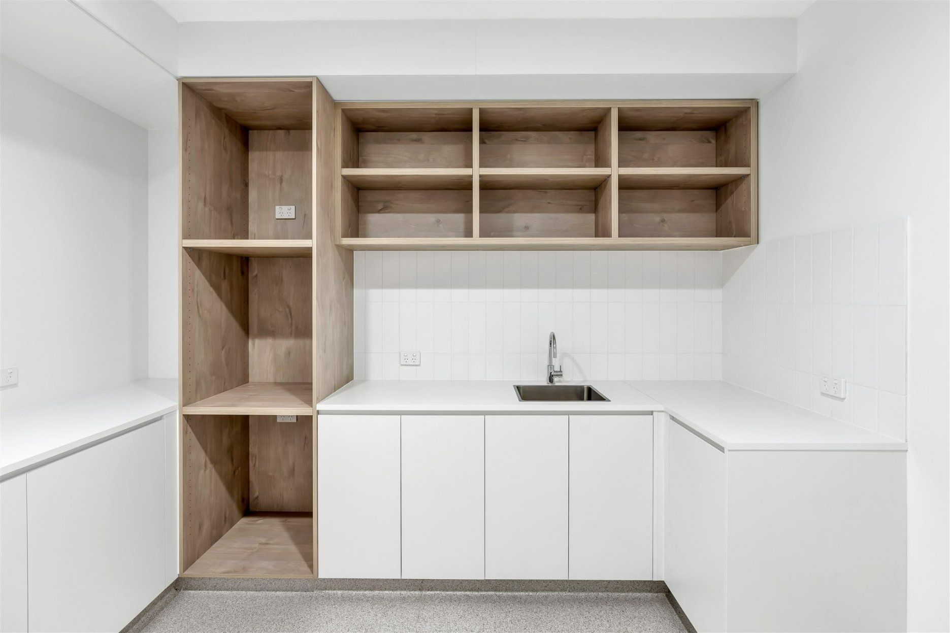 A Kitchen With White Cabinets and Wooden Shelves and a Sink — Moltus Construction in Braddon,  ACT