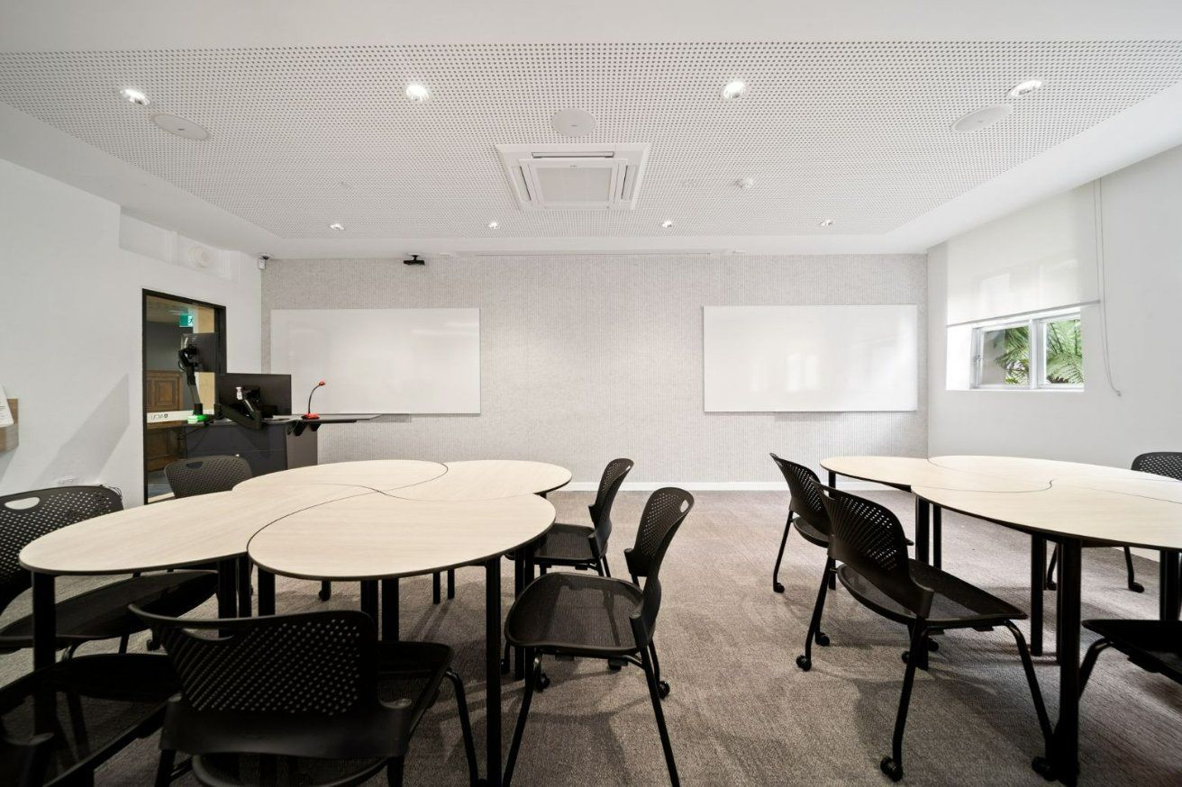 A Conference Room With Tables and Chairs and a Whiteboard — Moltus Construction in Braddon,  ACT