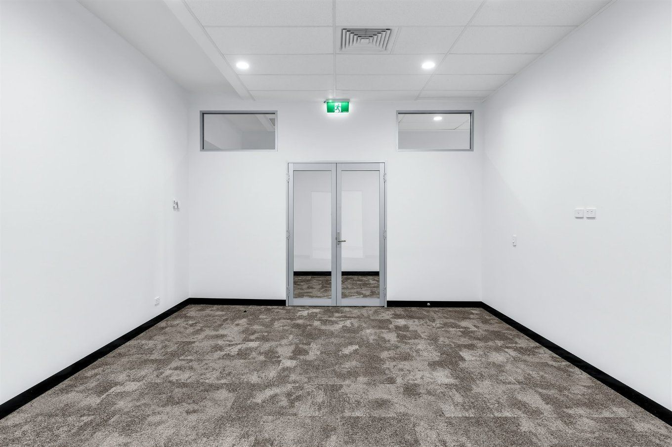 An Empty Room With a Carpeted Floor and a Glass Door — Moltus Construction in Braddon,  ACT
