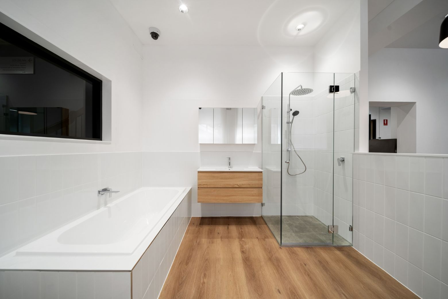 A Bathroom With a Bathtub, Sink, and Walk in Shower — Moltus Construction in Braddon,  ACT