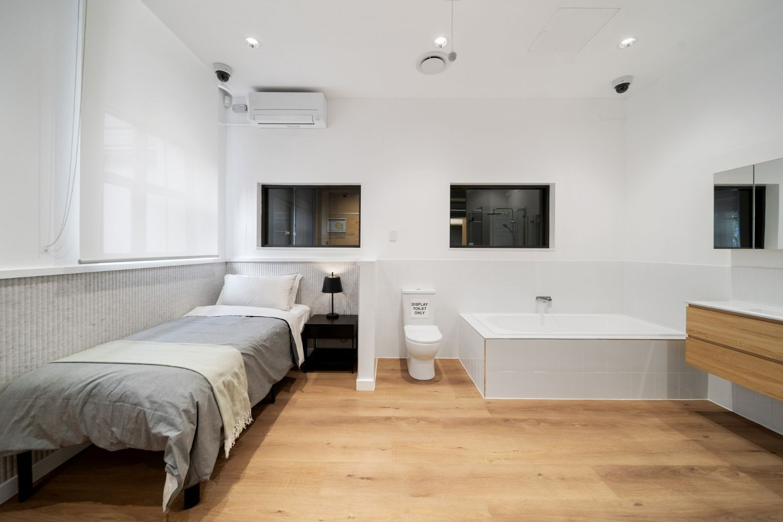 A Bedroom With Two Beds, a Toilet, and a Bathtub — Moltus Construction in Braddon,  ACT