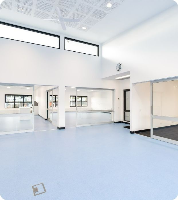 An Empty Room With a Blue Floor and White Walls — Moltus Construction in Braddon,  ACT