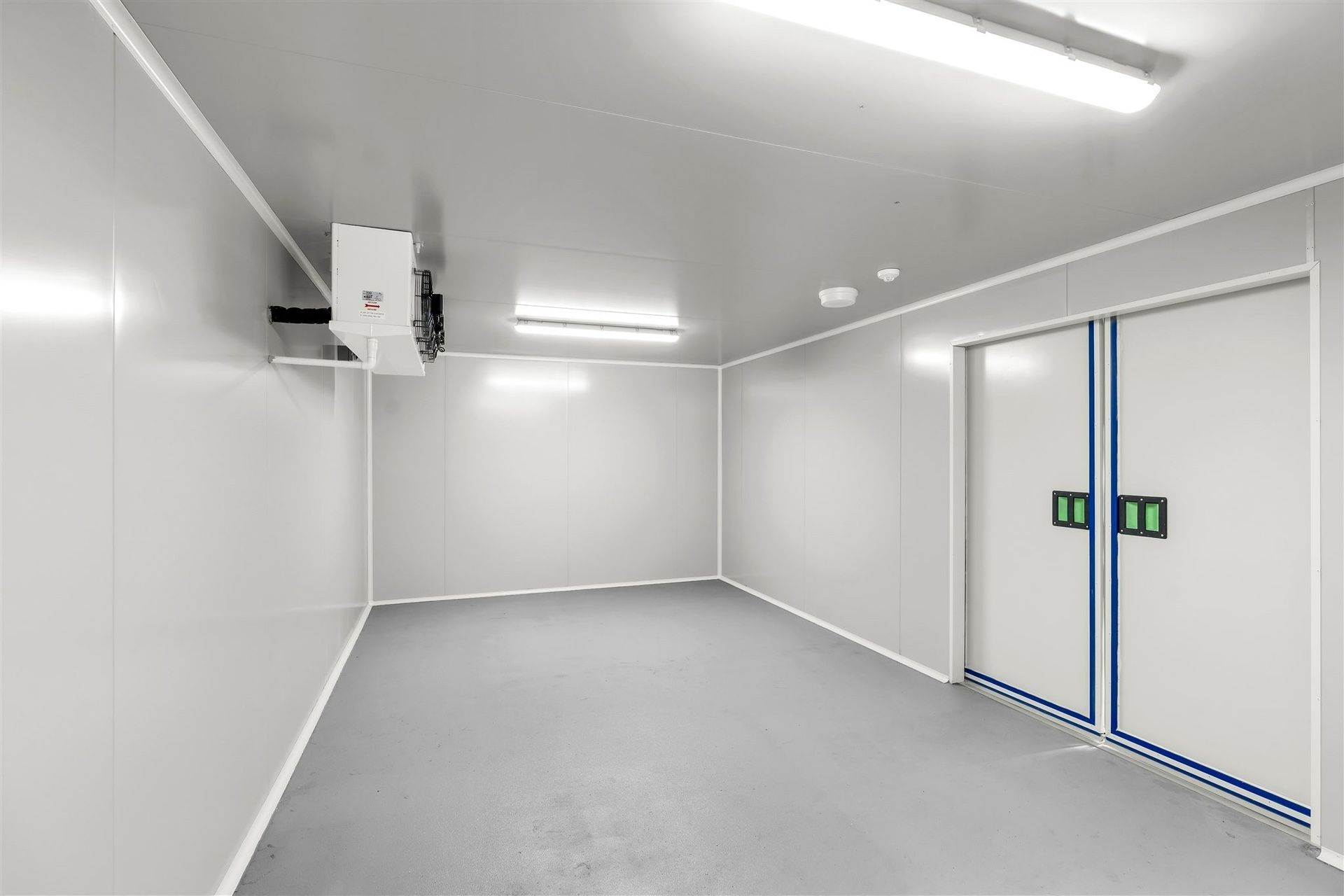 A Large Empty Room With White Walls and Sliding Doors — Moltus Construction in Braddon,  ACT