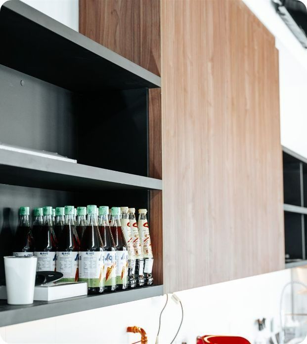 A Row of Bottles Are Sitting on a Shelf in a Kitchen — Moltus Construction in Braddon,  ACT