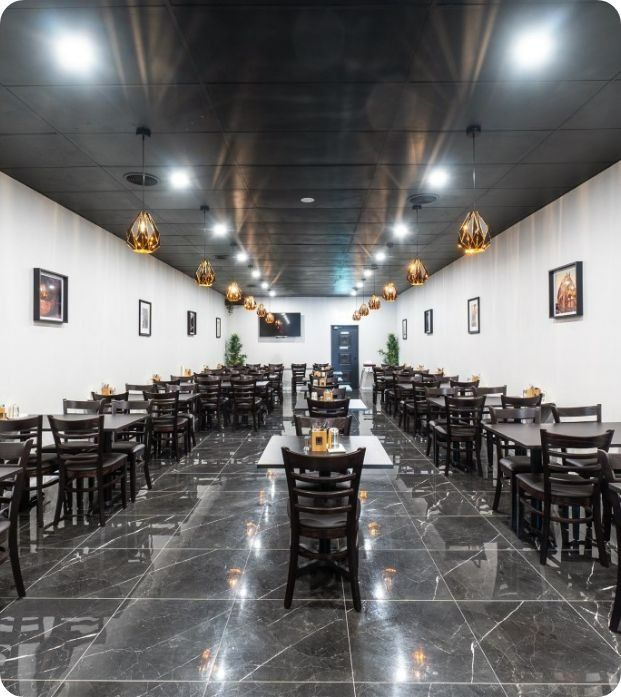 A Long Room With Tables and Chairs in a Restaurant — Moltus Construction in Braddon,  ACT