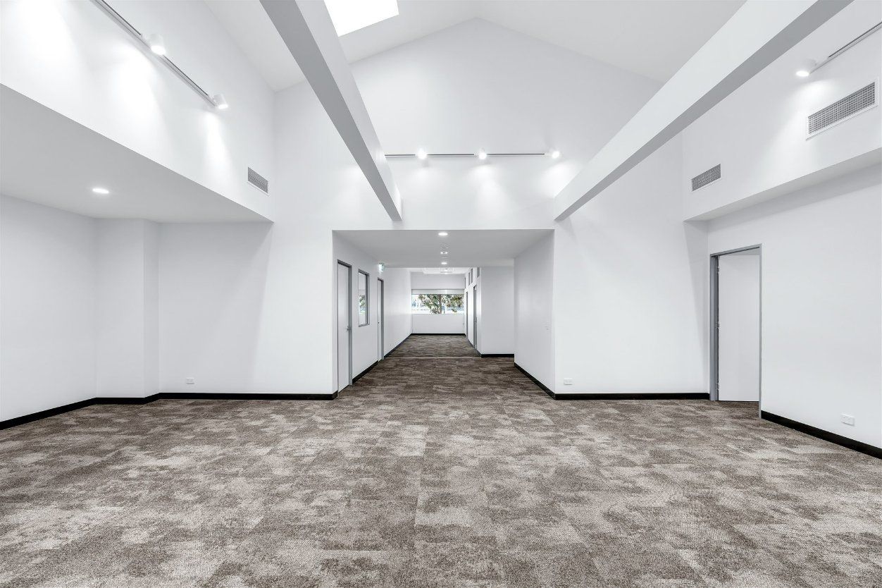 A Large Empty Room with white walls and ceiling — Moltus Construction in Sunshine Coast, QLD