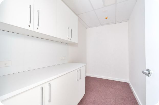 An Empty Room With White Cabinets and a Pink Carpet — Moltus Construction in Braddon,  ACT