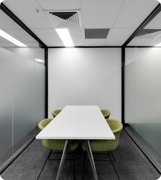 A Conference Room With A White Table And Green Chairs   — Moltus Construction in Brisbane, QLD