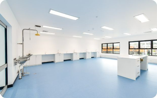 An Empty Room With Blue Floors and White Cabinets — Moltus Construction in Braddon,  ACT