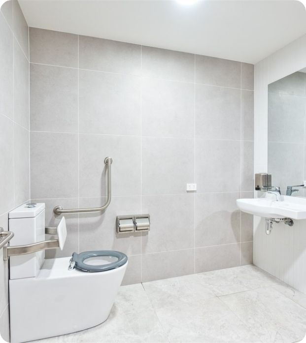 A Bathroom With a Toilet a Sink and a Mirror — Moltus Construction in Braddon,  ACT