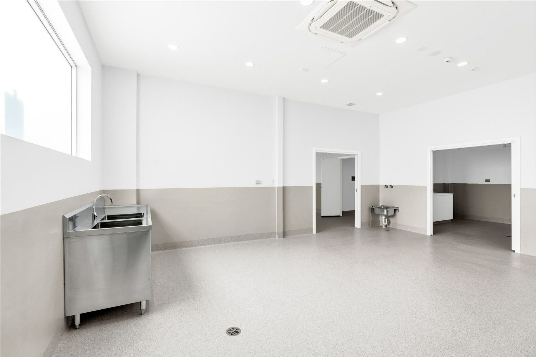 A Large Empty Room With a Sink and a Window — Moltus Construction in Braddon,  ACT