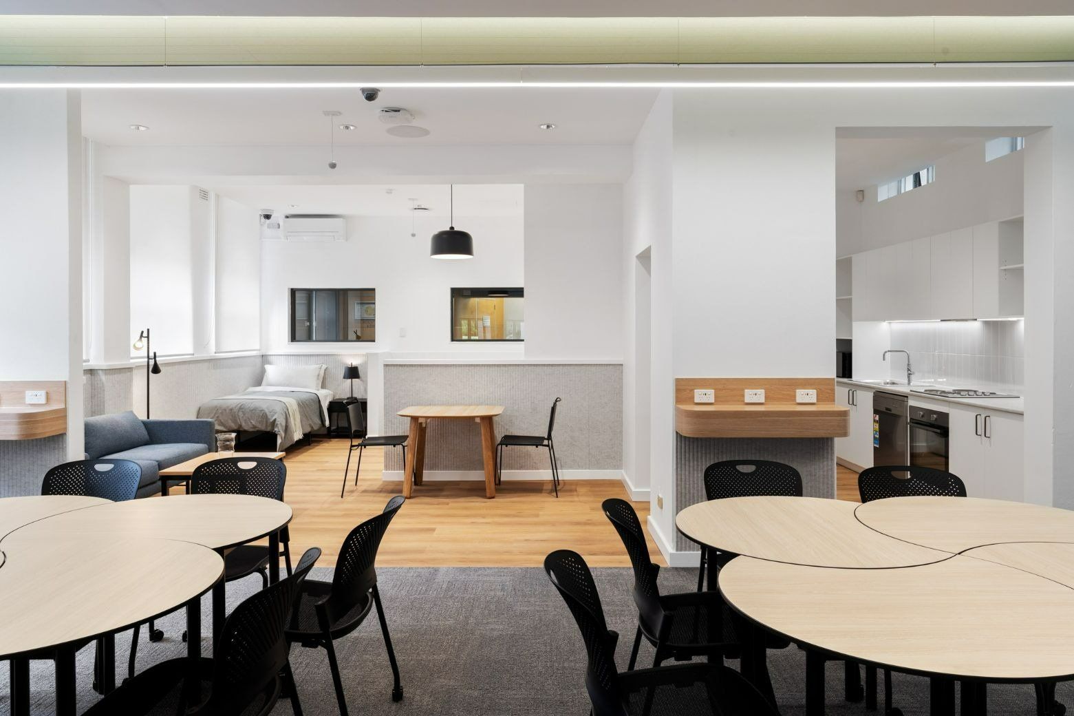 A Room With Tables and Chairs and a Bed in the Background — Moltus Construction in Braddon,  ACT