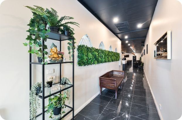 A Hallway With a Shelf Filled With Potted Plants and a Bench — Moltus Construction in Braddon,  ACT