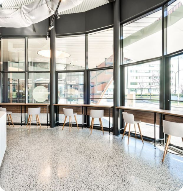 A Room With a Lot of Windows and Tables and Chairs — Moltus Construction in Braddon,  ACT