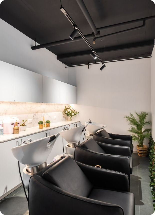 A Row of Black Chairs in a Salon With Sinks — Moltus Construction in Braddon,  ACT