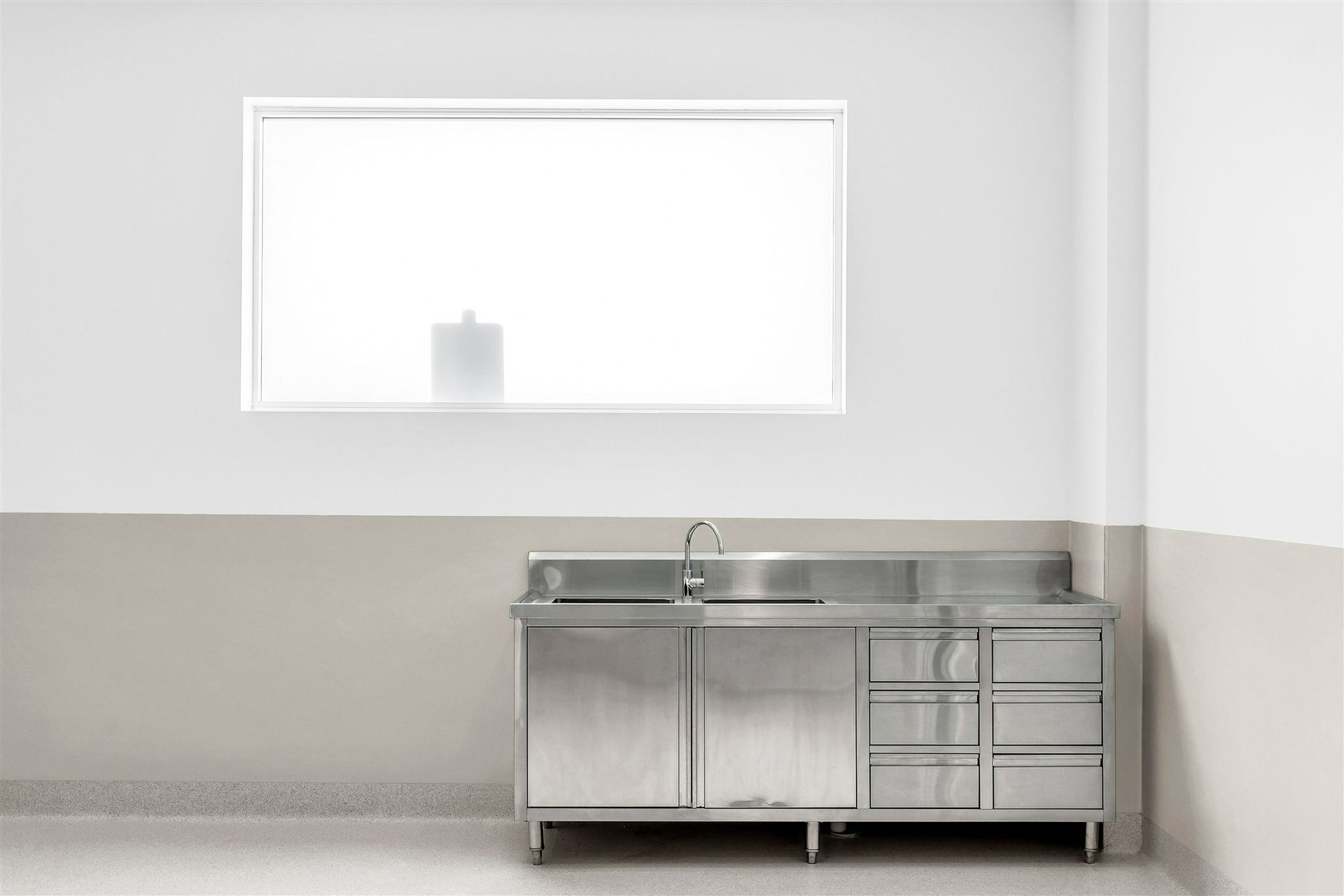 An Empty Room With a Stainless Steel Sink and a Window — Moltus Construction in Braddon,  ACT