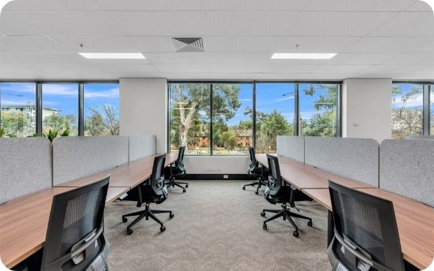 A Room With a Lot of Windows and Desks and Chairs — Moltus Construction in Braddon,  ACT