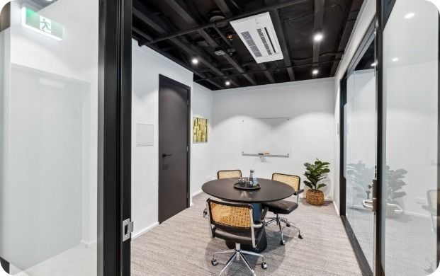A Conference Room With a Round Table and Chairs — Moltus Construction in Braddon, ACT