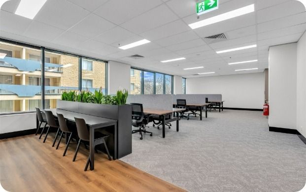A Large Room With a Lot of Windows and Tables and Chairs — Moltus Construction in Braddon,  ACT