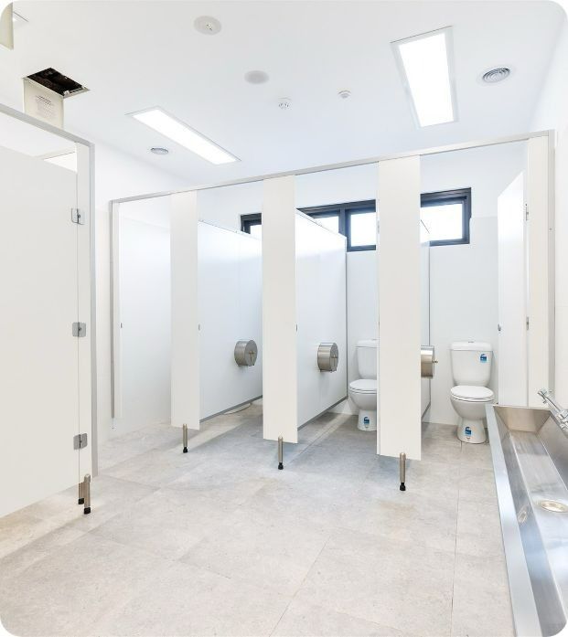A Public Restroom With Toilets and a Sink — Moltus Construction in Braddon,  ACT