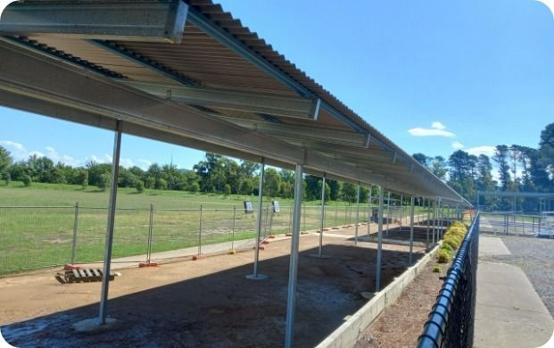 A Fenced in Area With a Covered Walkway Leading to a Field — Moltus Construction in Braddon,  ACT