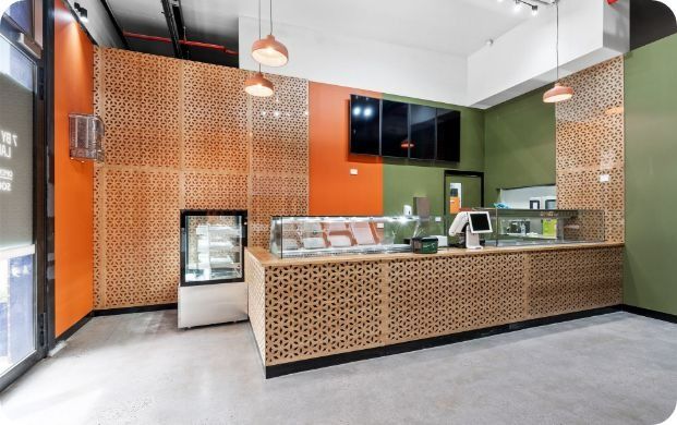 An Empty Restaurant With a Counter and a Display Case — Moltus Construction in Braddon,  ACT