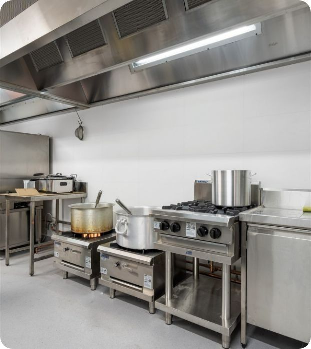 A Kitchen With a Lot of Pots and Pans on the Stove — Moltus Construction in Braddon,  ACT