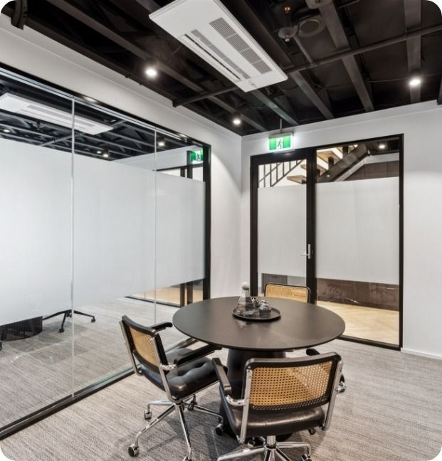 A Conference Room With a Round Table and Chairs — Moltus Construction in Braddon,  ACT