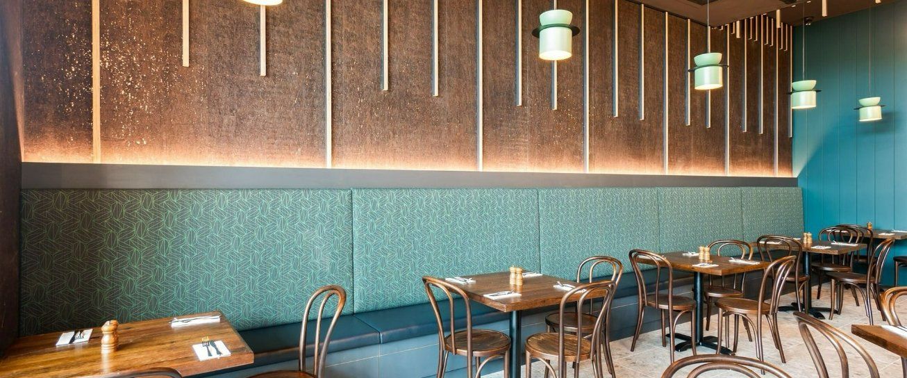 A Restaurant With Tables and Chairs and a Blue Wall — Moltus Construction in Braddon,  ACT