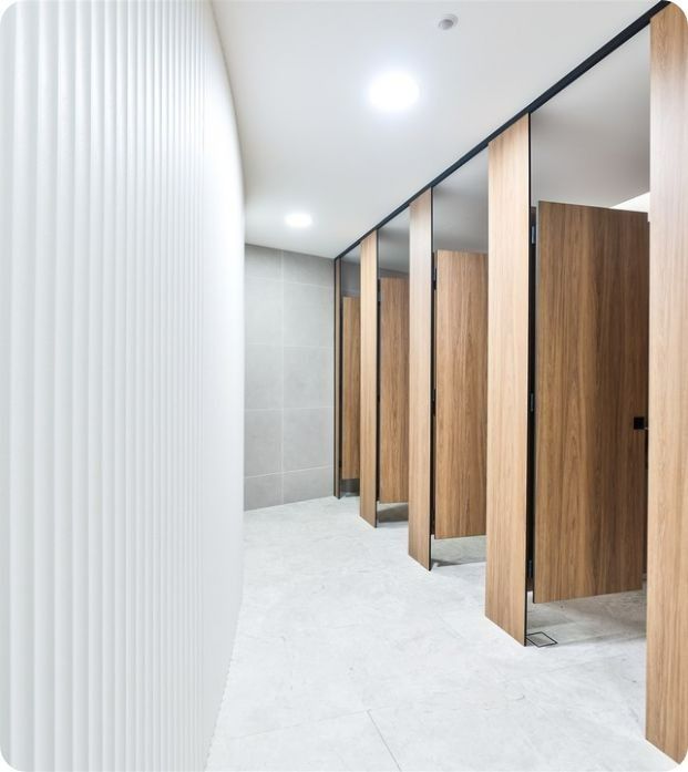 A Row of Wooden Stalls in a Public Restroom — Moltus Construction in Braddon,  ACT