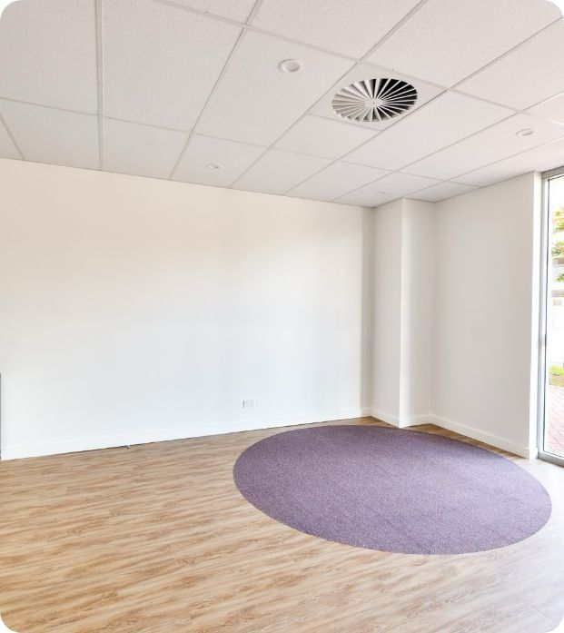 An Empty Room With a Purple Rug on the Floor — Moltus Construction in Braddon,  ACT