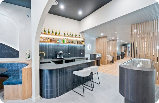 A Kitchen With a Bar and Stools in It — Moltus Construction in Braddon,  ACT