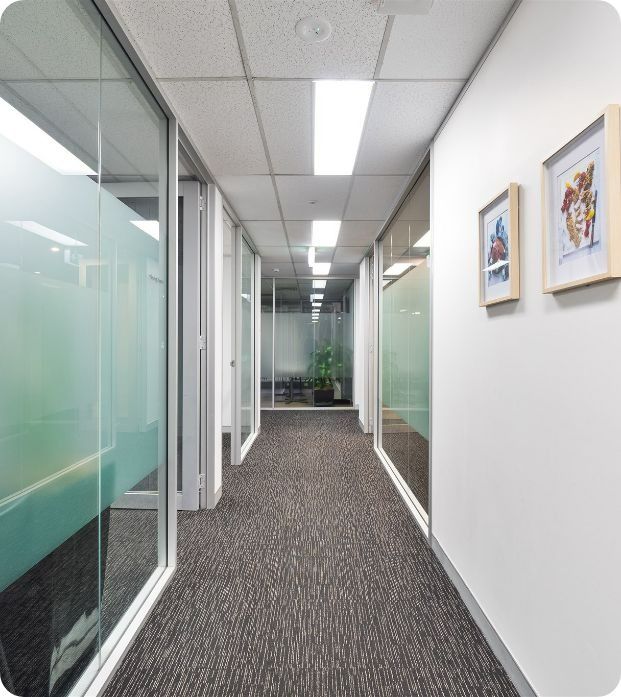 A Hallway With Two Framed Pictures on the Wall — Moltus Construction in Braddon,  ACT