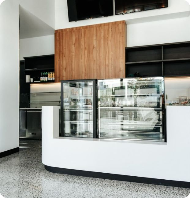 A Counter in a Restaurant With a Glass Display Case — Moltus Construction in Braddon,  ACT