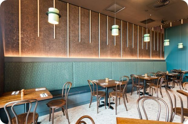 A Restaurant With Tables and Chairs and a Blue Wall — Moltus Construction in Braddon,  ACT
