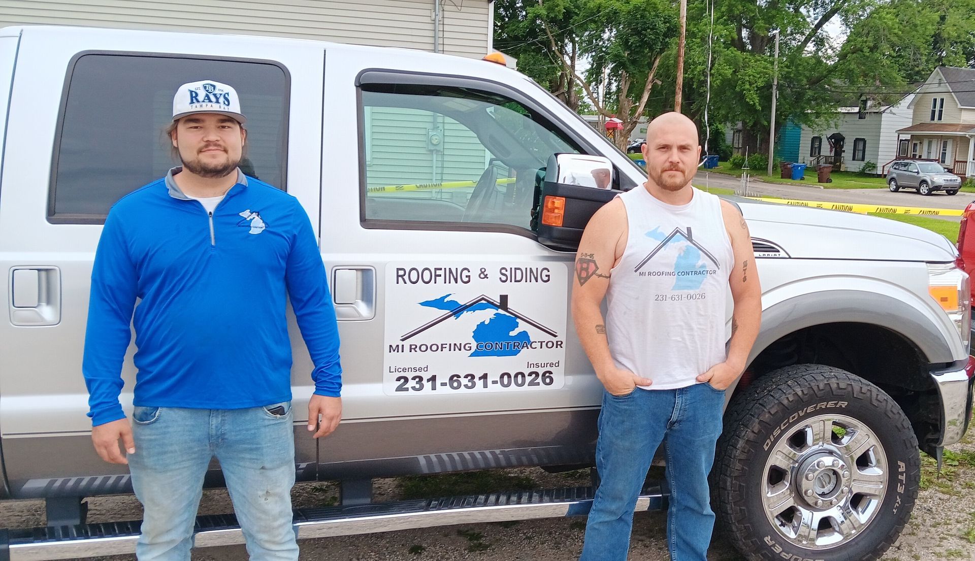 Two men are standing in front of a truck.