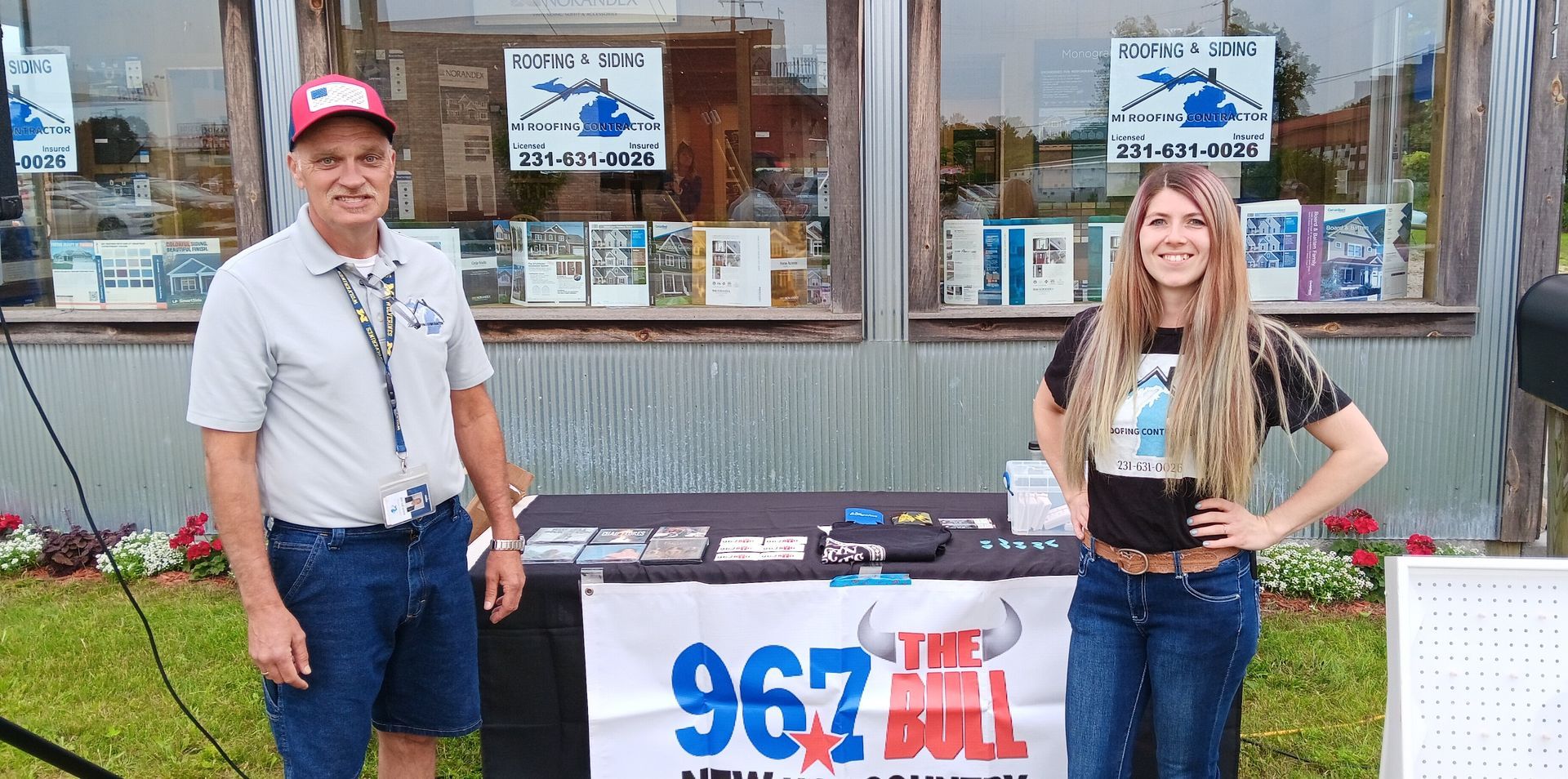 A man and a woman are standing in front of a table with a sign that says 967 bull.