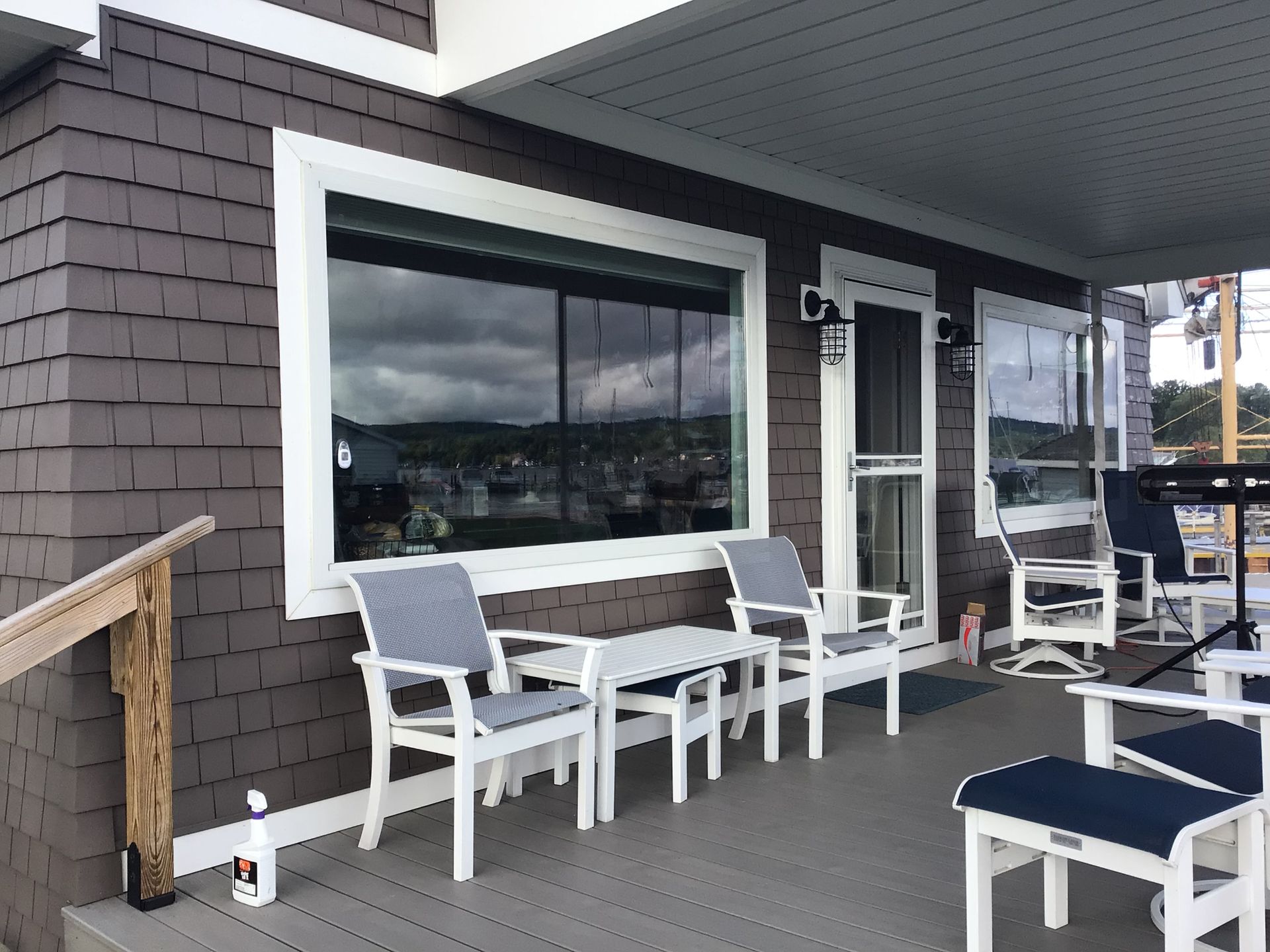 A porch with chairs , a table and a window.