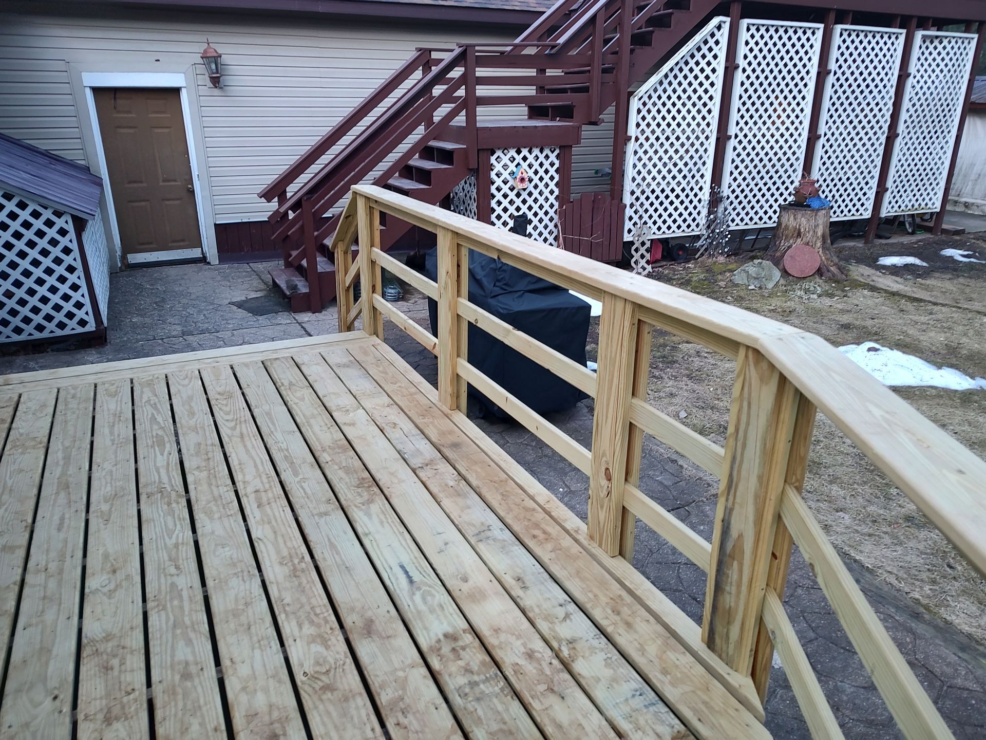 A wooden deck with stairs leading up to a house