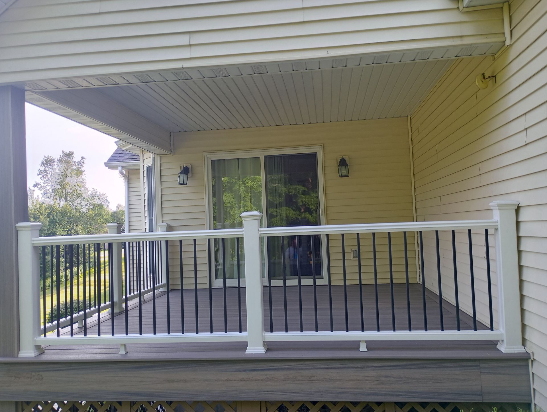 A porch with a white railing and a sliding glass door
