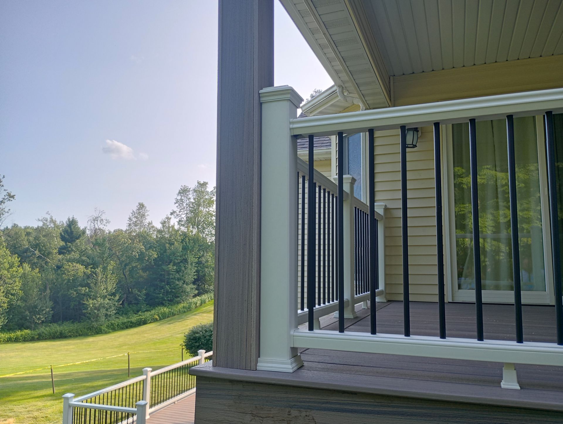 A deck with a white railing and a sliding glass door.
