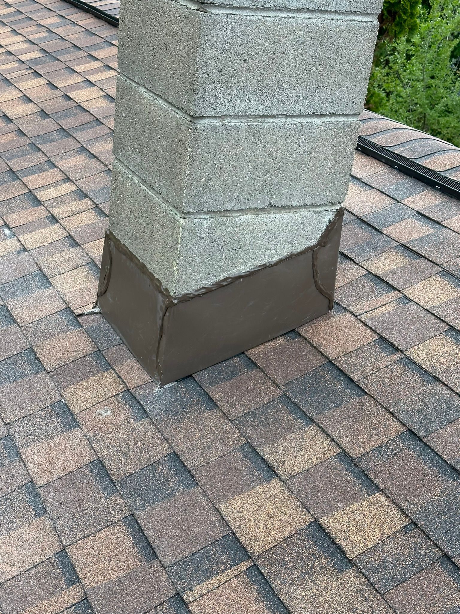 A chimney is sitting on top of a brick roof.