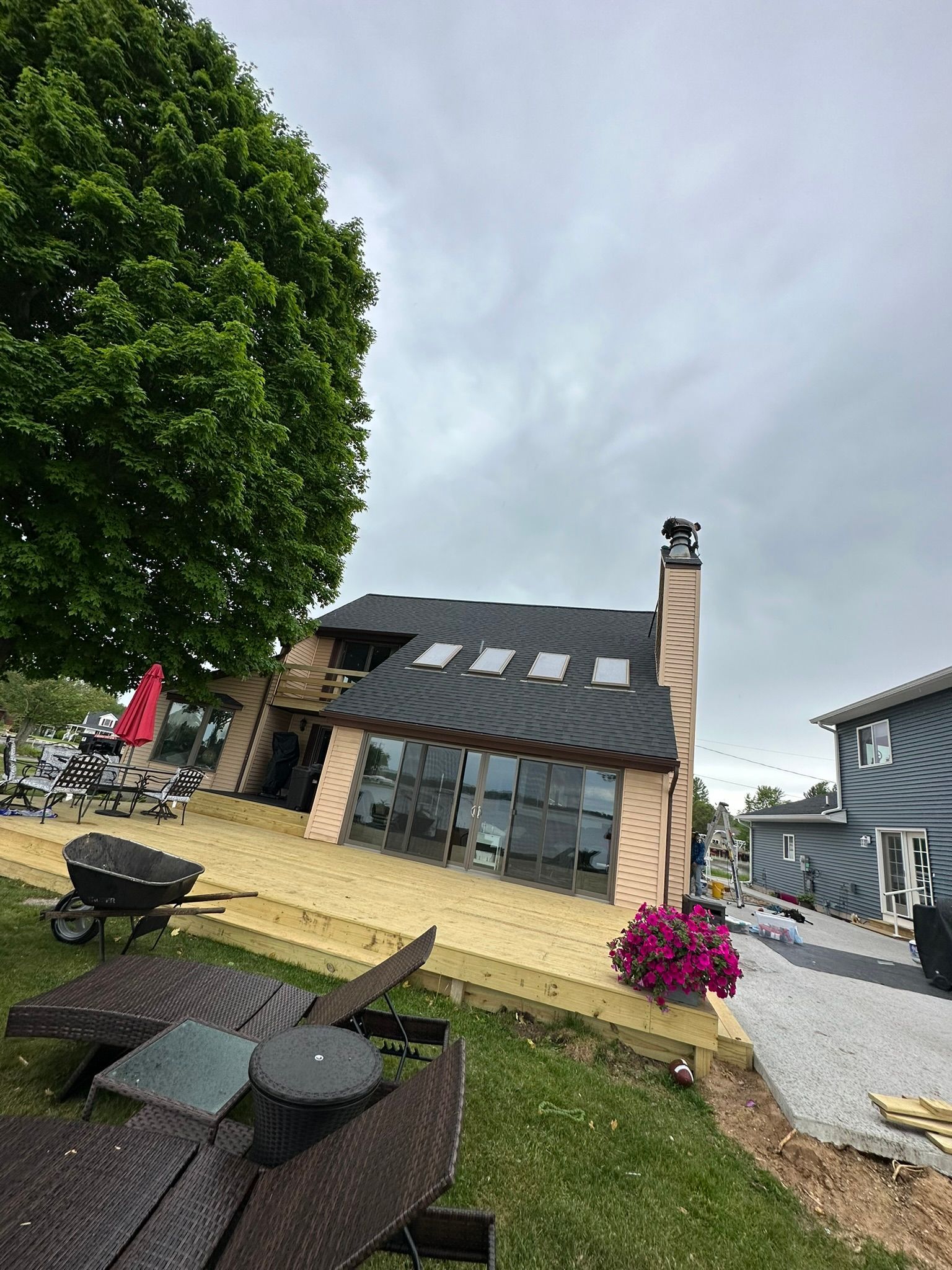 A large house with a roof that is being installed is being built.