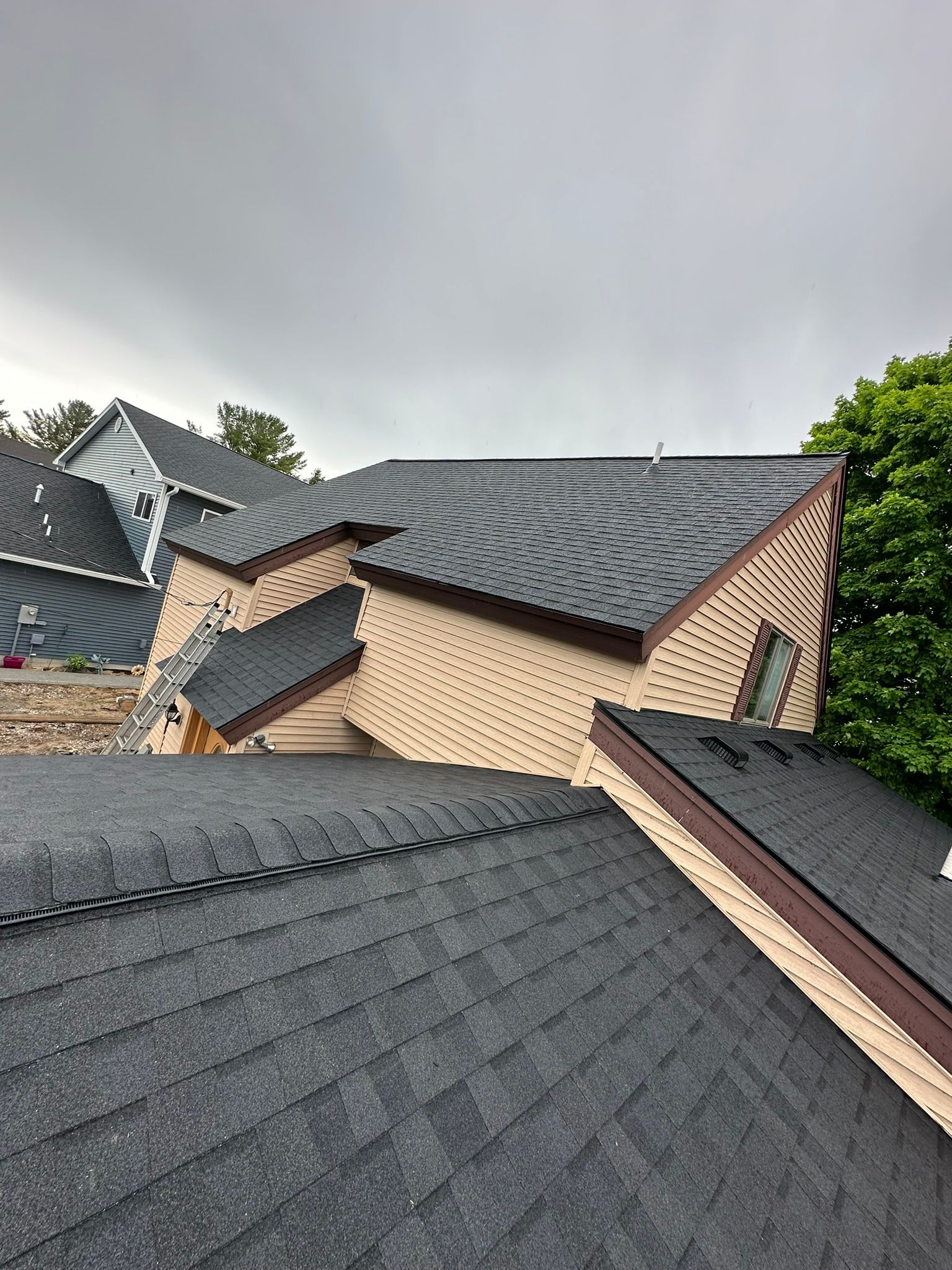 A house with a roof that is being installed on a cloudy day.