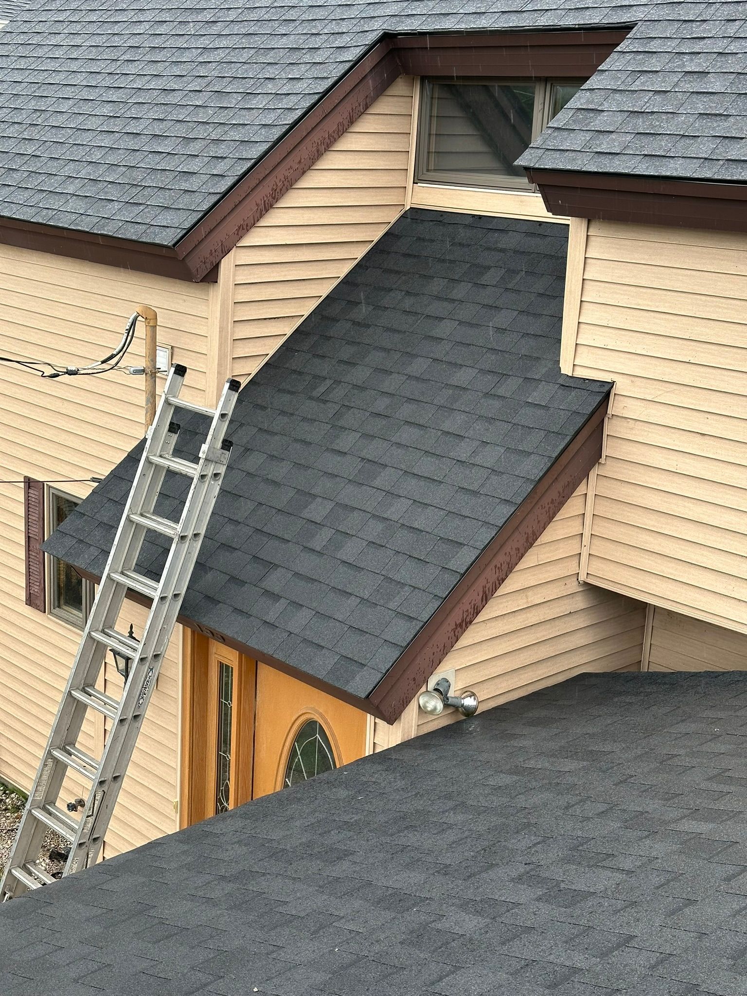 A ladder is sitting on the roof of a house.
