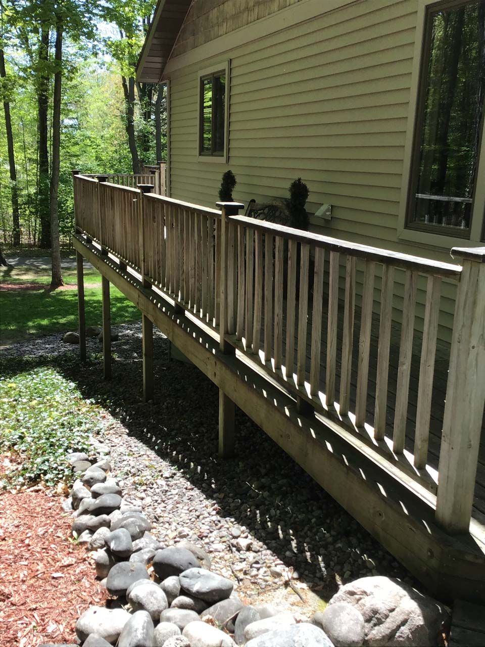A house with a wooden deck in front of it