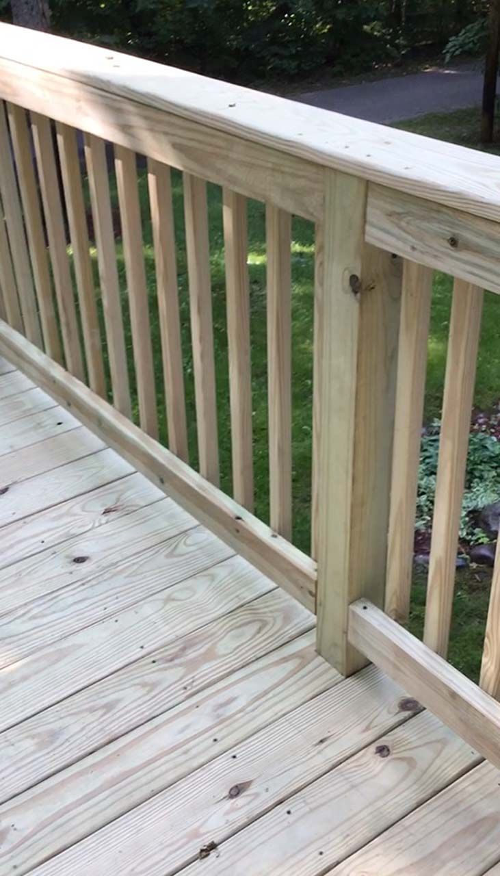 A close up of a wooden deck with a railing.