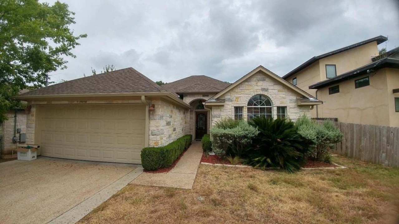 A house with a garage and a fence in front of it